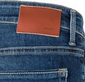 Detail van de achterkant van een blauwe jeans met een bruin lederen MAC JEANS label.