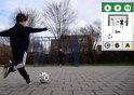 Jongen schiet bal op een plein, met een goal en een kind op de achtergrond. Kaart met voetbalspel illustraties.