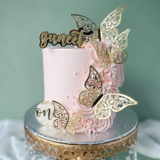 Roze taart versierd met gouden vlindertopper, rozen en parels. Met 'Guneet' tekst.
