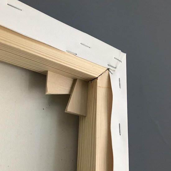 Gros plan du coin d'une toile blanche avec un cadre en bois et des renforts.