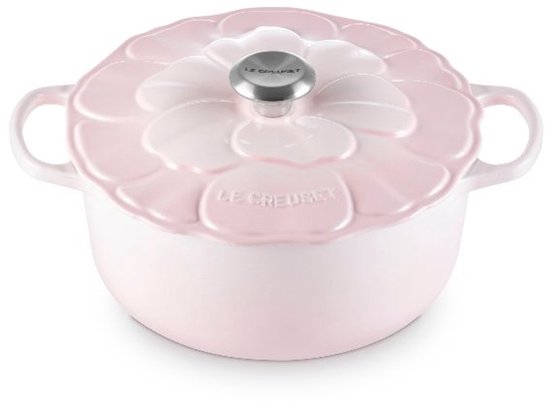 Zijaanzicht van een roze Le Creuset braadpan met bloemvormig deksel en zilverkleurig handvat.
