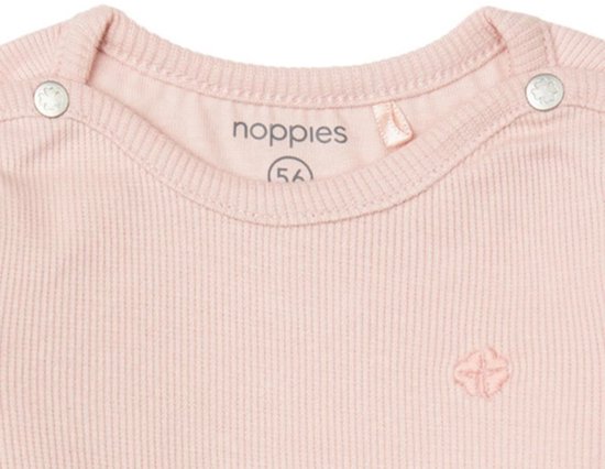 Close-up van een lichtroze baby body met fijne ribbels en drukknoopjes bij de kraag. Het merk 'noppies' is zichtbaar.