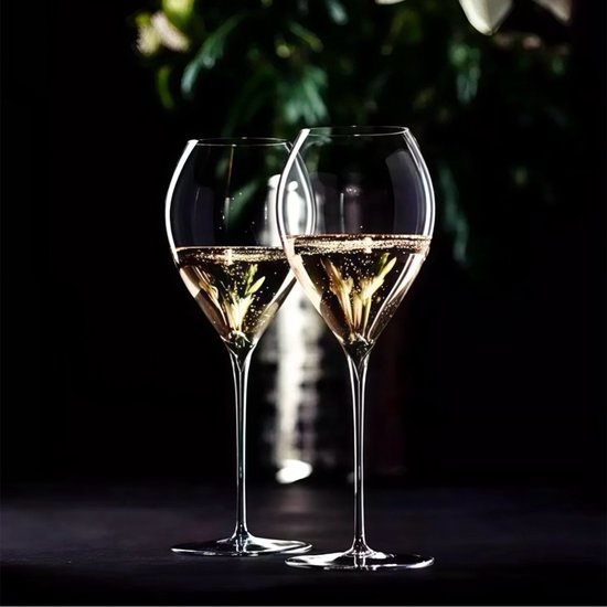 Deux verres à champagne Grand Champagne Jamesse remplis de champagne, avec de fines bulles, sur fond sombre.