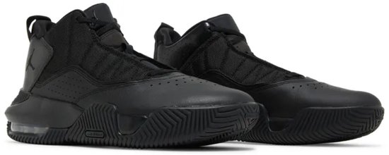 Twee zwarte Jordan Stay Loyal 2 sneakers op een witte achtergrond, met leren en mesh bovenwerk.