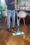 Man poetst houten vloer met Leifheit Easy Spray XL vloerwisser.