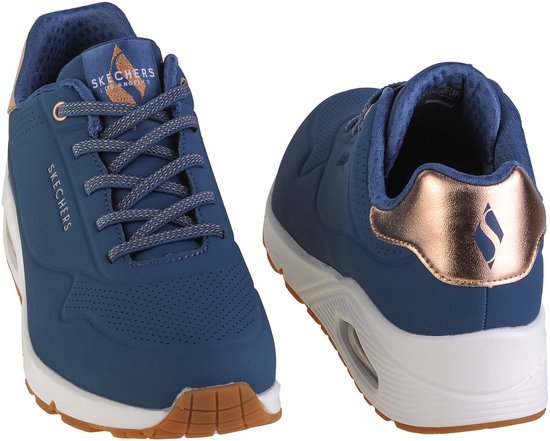 Set van twee blauwe Skechers Uno sneakers, één van voren en één van achteren, met roze gouden details.