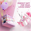 Roze geschenkdoos met wolken en regenboog, met drie ballonnen, twee witte cadeauboxen met roze strikken en twee Arrtx acrylmarkers.