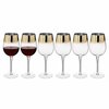 Ensemble de 6 verres à vin, dont deux remplis de vin rouge, avec des bords dorés.