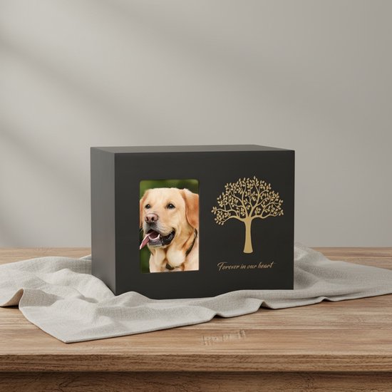 Zwarte urn met gouden boom en tekst 'Forever in our heart', met een foto van een lachende labrador.