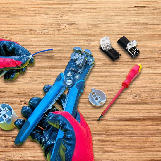 Gedemonteerde zwarte kabelconnectoren met doorzichtige delen op een houten ondergrond. Naast gereedschap zoals een draadstripper en schroevendraaier.