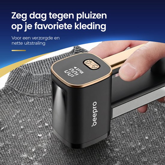 Een hand houdt een zwarte en gouden pluizenverwijderaar vast op een gebreide grijze stof. De tekst zegt: "Zeg dag tegen pluizen op je favoriete kleding"