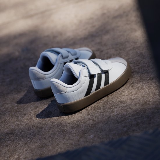 Wit met zwarte strepen, de zolen van deze kinderschoenen zijn bruin met klittenbandsluiting.