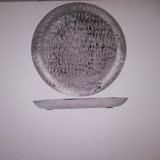 Zilverkleurige, ronde schaal van aluminium met een gedetailleerd, rasterachtig patroon.