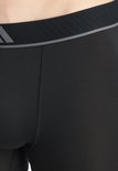 Close-up van de grijze, gestreepte tailleband van zwarte Adidas boxershorts.