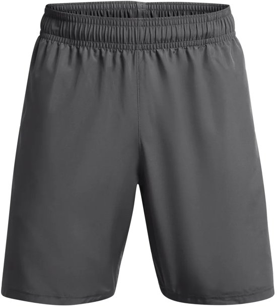 Grijze sportbroek van Under Armour met witte tekst op de zijkant, gedragen door een man.