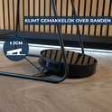 Zwarte robotstofzuiger klimt over metalen poot, met aanduiding 2 cm.