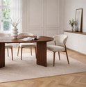 Ovale eettafel van donker hout met drie beige stoffen stoelen met houten frame.