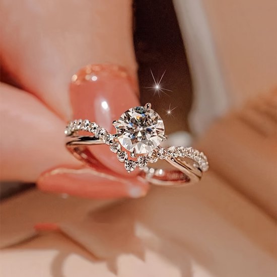 Zilverkleurige ring bezet met een grote ronde zirkonia en kleine steentjes op de band.
