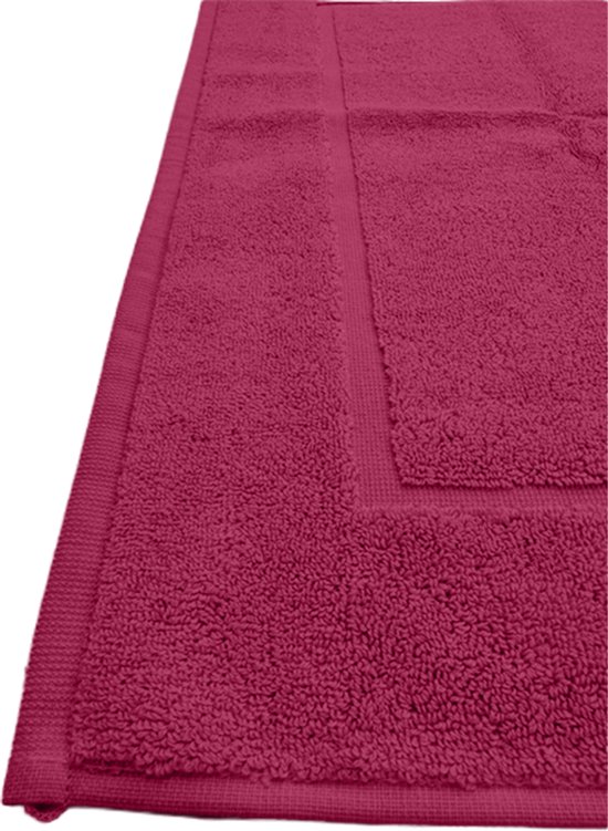 Detail van de fuchsia badmat met zijn zachte textuur en kader.