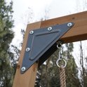 Houten ringen met touwen hangen aan een houten balk van een speeltoestel.