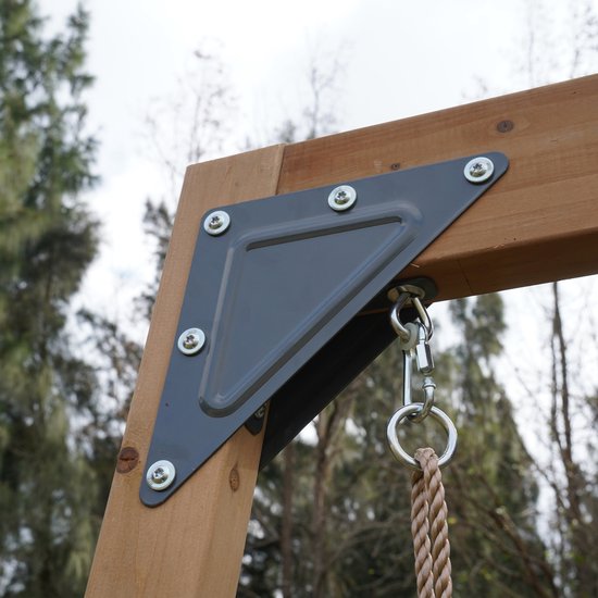 Houten ringen met touwen hangen aan een houten balk van een speeltoestel.