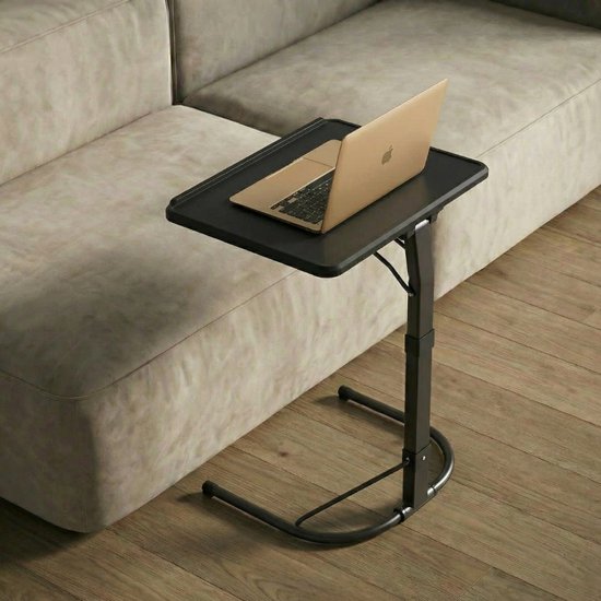 Zwarte laptoptafel met een laptop erop, naast een beige bank.