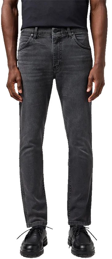 Man in een grijze spijkerbroek van Wrangler met een slim fit en knoopsluiting.