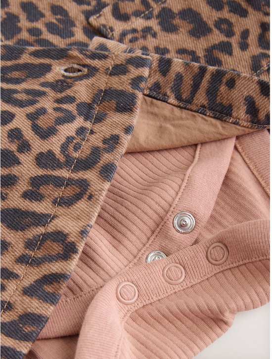 Roze ribgebreide romper met drukknoopsluiting onderaan en een luipaardprint denim overslag.