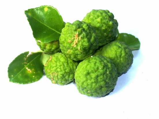 Groene, ruwe bergamotvruchten met bladeren.