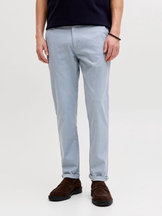 Onderlichaam van een man met een lichtblauwe pantalon met ruitpatroon en omgeslagen pijpen.