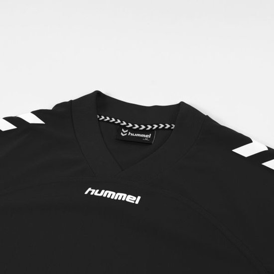 Detail van de hals van een zwart hummel sportshirt met witte tekst en witte hummel chevrons.