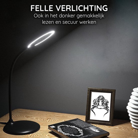 Lampe de bureau noire avec éclairage LED rond, posée sur un bureau à côté d'un livre et d'un cadre photo.