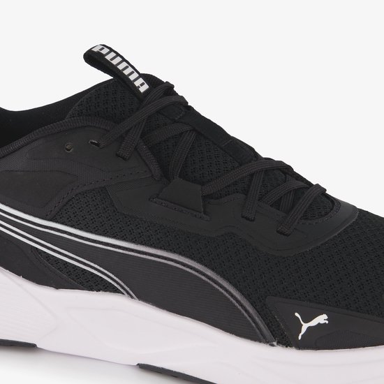 Close-up van een zwarte PUMA sportschoen met witte accenten en veters. PUMA logo op de zijkant.