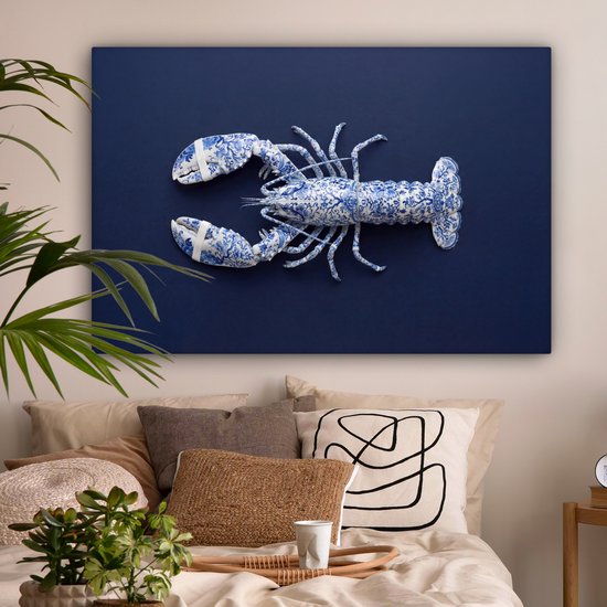 Delftsblauwe kreeft in blauw en wit op een donkerblauwe achtergrond, boven een bed met veel kussens.