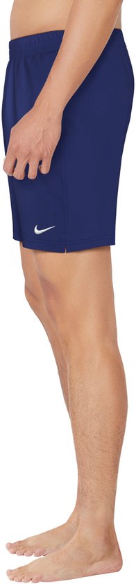 Zijaanzicht van een man met marineblauwe Nike zwembroek met witte swoosh.