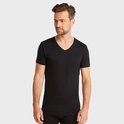 Man met een zwarte t-shirt met v-hals en korte mouwen, staand.