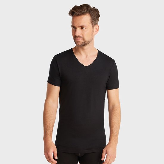 Man met een zwarte t-shirt met v-hals en korte mouwen, staand.