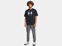 Man in zwarte Under Armour t-shirt met logo en grijze cargo trainingsbroek.