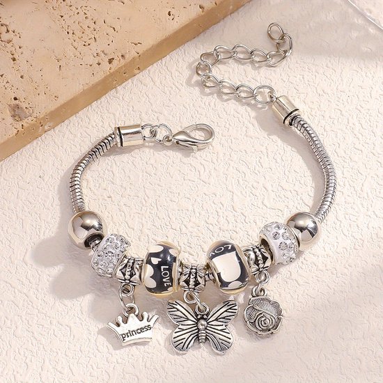 Zilverkleurige bedelarmband met 'Princess'-kroon, vlinder, roos, en kraaltjes met 'LOVE'-tekst.
