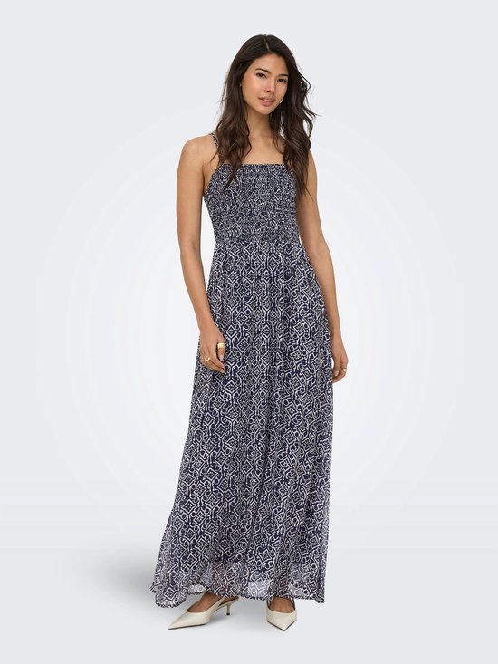 Maxi jurk met spaghettibandjes en gerimpeld lijfje in marineblauw met een witte geometrische print, gedragen door een vrouw.