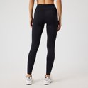 Dames zwarte sportlegging van Björn Borg, gezien vanaf de achterkant, met witte sportschoenen.