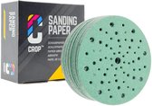 Groene schuurschijven met veel gaatjes, naast een doos met 'CROP SANDING PAPER' erop.