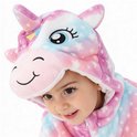 Een jong kind met een capuchon van een eenhoorn onesie met eenhoorn details en sterrenprint in roze, blauw en wit.