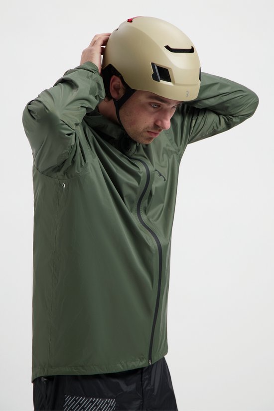 Man met helm, trekt de capuchon van zijn olijfgroene regenjas aan.