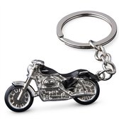 Gedetailleerde zilverkleurige en zwart metalen motor sleutelhanger op een witte achtergrond.