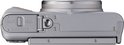 Onderkant van een zilverkleurige Canon PowerShot SX740 HS camera met batterij- en kaartdeksel.