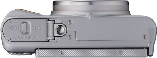 Onderkant van een zilverkleurige Canon PowerShot SX740 HS camera met batterij- en kaartdeksel.