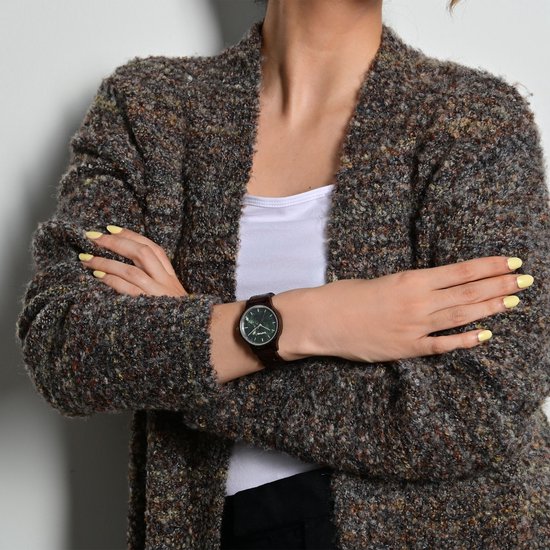 Vrouw met een bruine gebreide vest, draagt een Raptor horloge met donkerhouten band en donkergroene wijzerplaat.