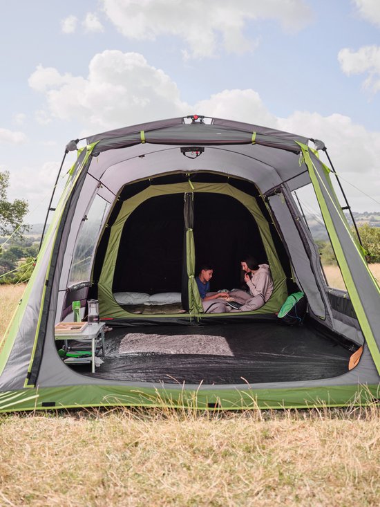 Een gezin geniet van een tent met Coleman BlackOut Bedroom technologie. "Coleman Blackout Bedroom Technology" en "Keeps up to 99% of daylight out of your sleeping area." op de afbeelding.