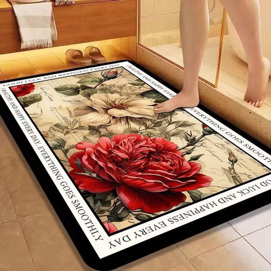 Badmat met grote rode en witte rozen en tekst rondom. Een voet staat erop in een badkamer.